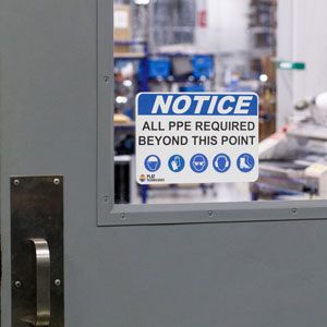 Blue sign on a door indicating PPE required to enter.