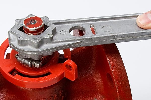 A LOTO device on a red plug valve.
