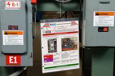 Two electrical panels with LOTO instructions hanging between them. 