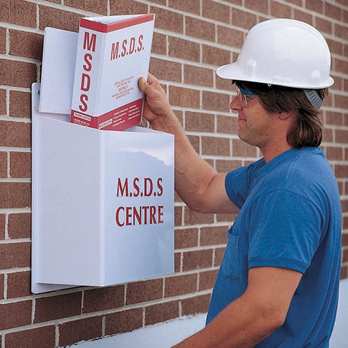 A worker in hardhat removes a MSDS binder from its case.
