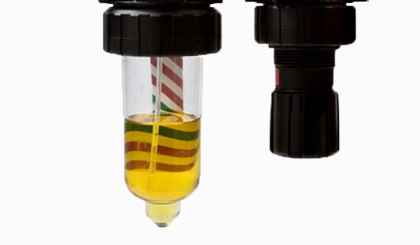 Closeup of two liquid holding glassware items with labels. 