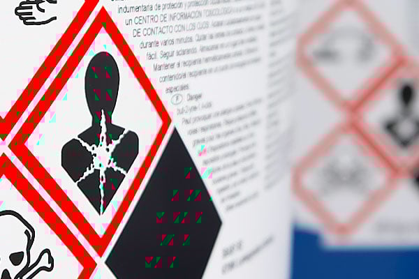 A closeup of bottles bearing hazardous pictograms.