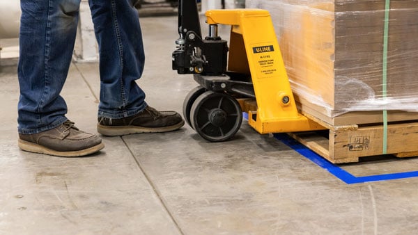 Pallet jack rolling over Brady ToughStripe Max floor tape.