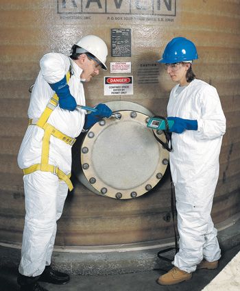 Workers in PPE apply LOTO devices to hatch on a door.