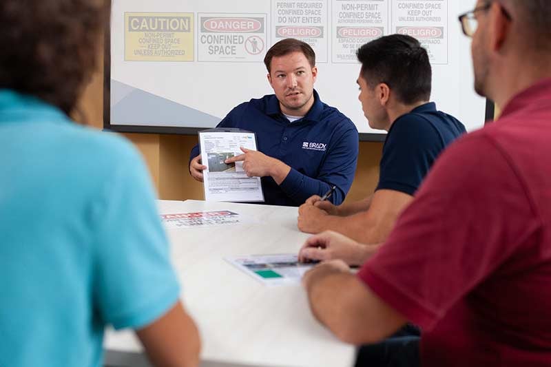 Employees receive instruction at a corporate training meeting.