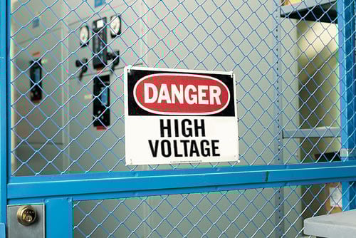 Danger high voltage sign in front of electrical equipment.