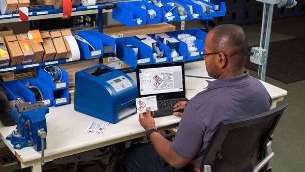 Tech prints labels in an industrial setting. 