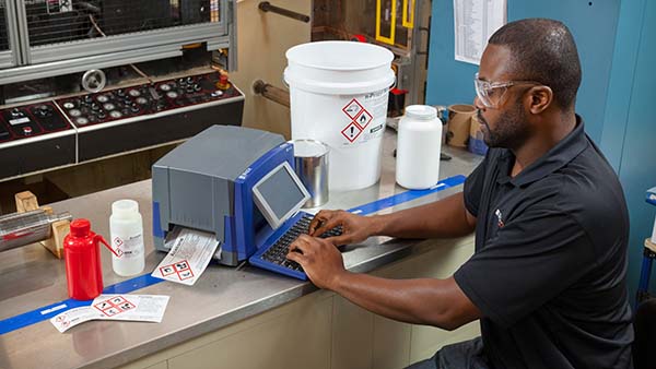 Tech prints labels in an industrial setting.