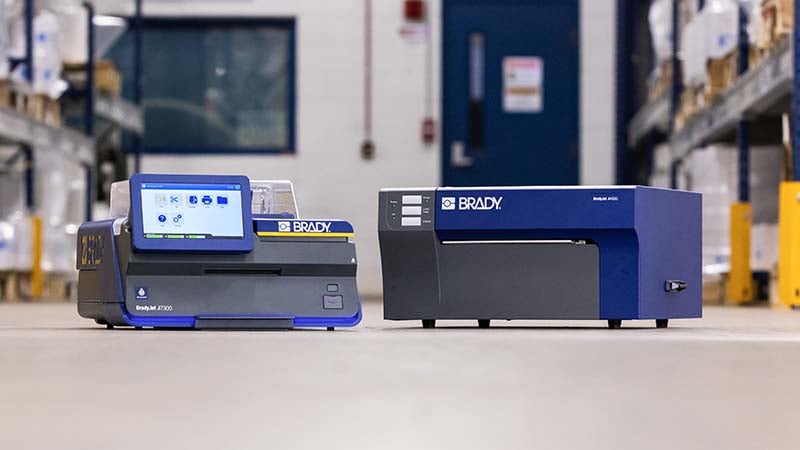 Two BradyJet label printers on a floor in a warehouse.