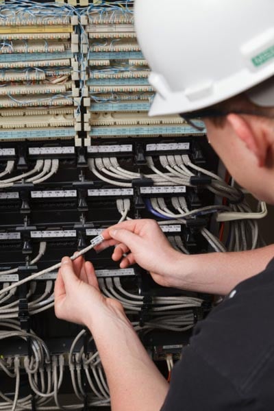 A datacom worker inspecting labels for TIA-942 compliance.