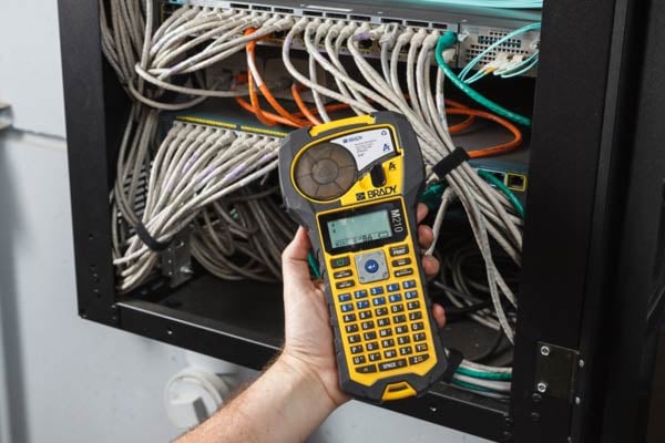 Custom labels are printed with a Brady M210 Printer for a server rack.