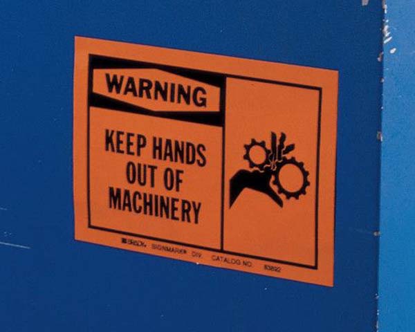 Orange safety sign about keeping hands off machinery.