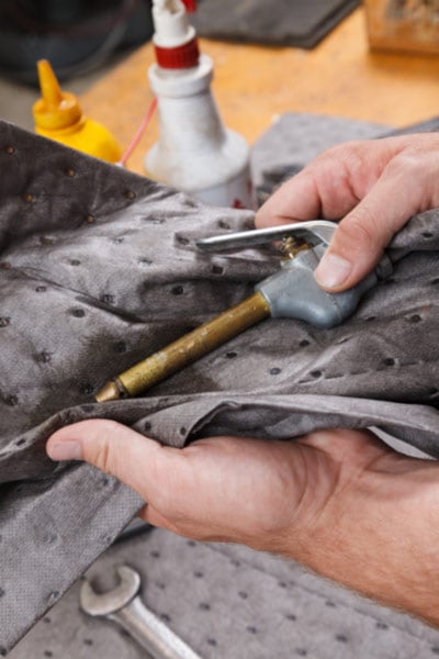 Using an absorbent pad to clean tools.