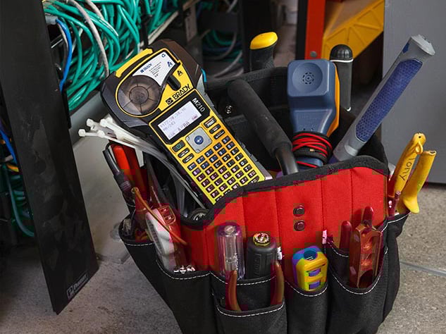 A Brady M210 Printer in an electrician&#x2019;s tool bag.