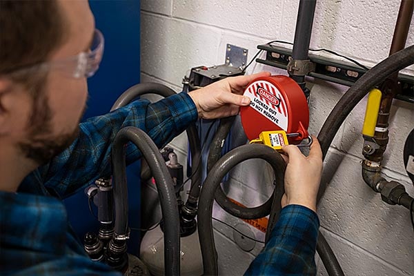 Employee attaching a lock to a Brady valve cover.