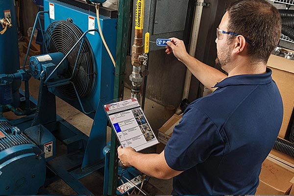 Employee inspecting a compressed air safety tag.