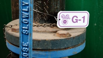 Pipe with a &quot;G-1&quot; identification tag and &quot;close slowly&quot; warning.