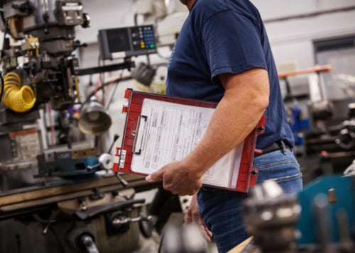 Employee holding a checklist for a documented lockout tagout program.