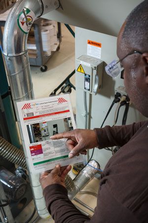 A man reviews printed LOTO procedures near equipment.