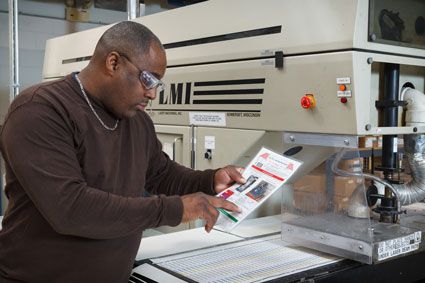 A man in goggles reviews Brady LOTO printed procedure.