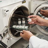 Surgical instruments being removed from a sterilization machine.