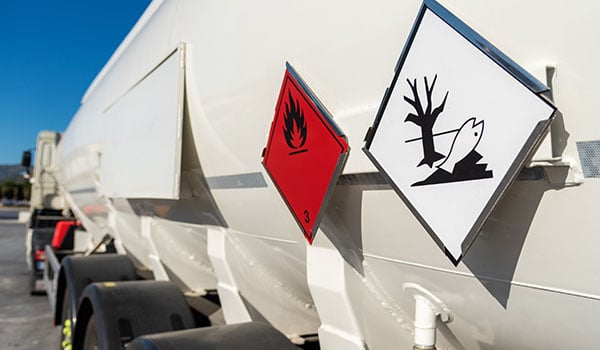 Hazmat signs on the sides of a tanker truck.