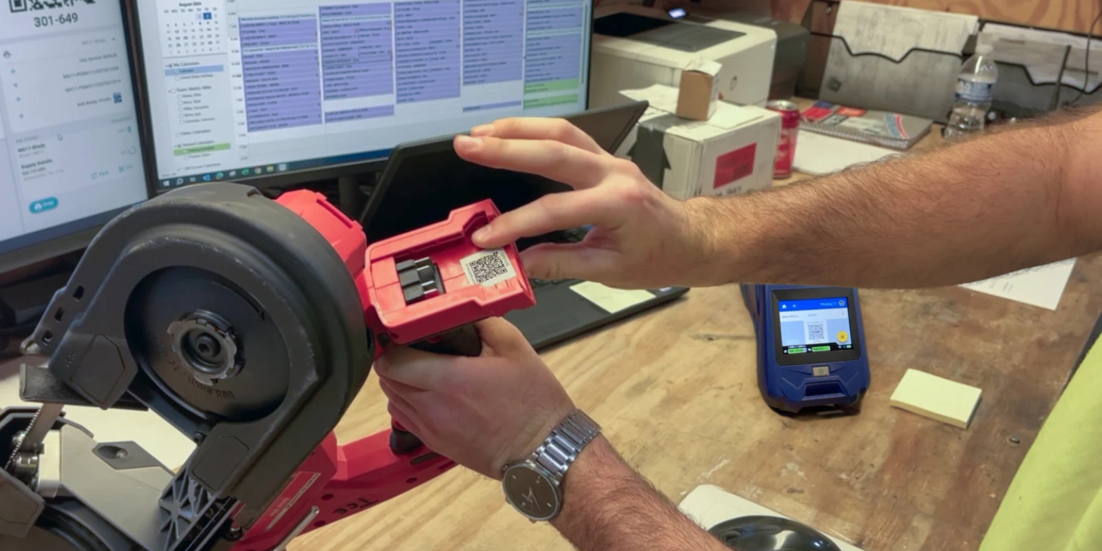 Person attaching a printed 2D barcode to a piece of equipment.