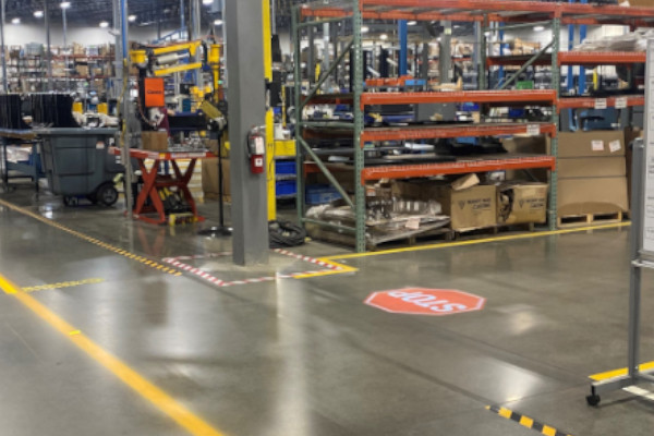 Projected lines and a projected stop sign on a manufacturing floor.