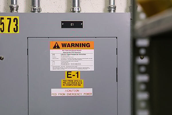 An electrical panel with arc flash warning and lockout point identification labels.