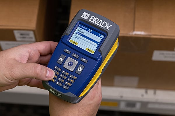 A worker reviewing the screen of a V4500 handheld scanner.
