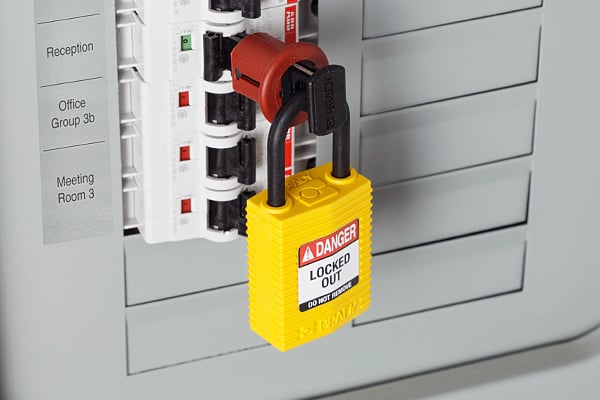 A yellow nylon lock used with a circuit breaker lockout on an electrical panel.