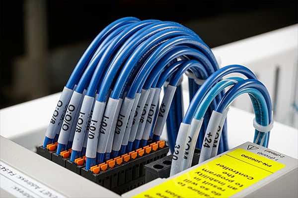 A collection of cables with identification labels in a patch panel.