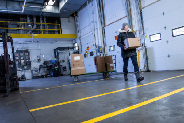 a person walking across a shipping area with area marking strips