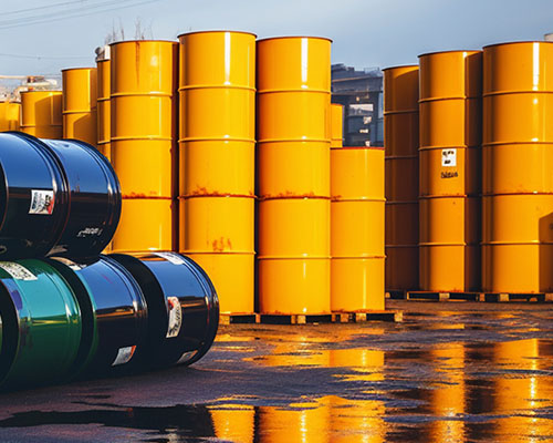 A collection of large yellow steel drums stacked on top of each other outdoors.