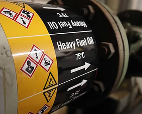 Heavy fuel oil pipe marked with a warning label