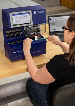 An employee using a Brady Wraptor printer.