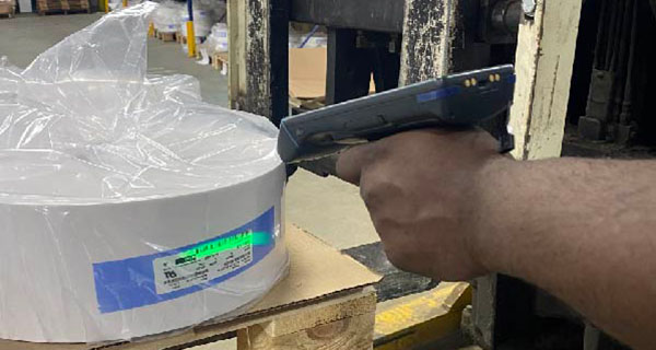 Brady HH83 handheld barcode scanner at work scanning roll of labels.