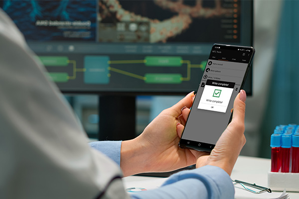 Smartphone being held with checkmark on screen.