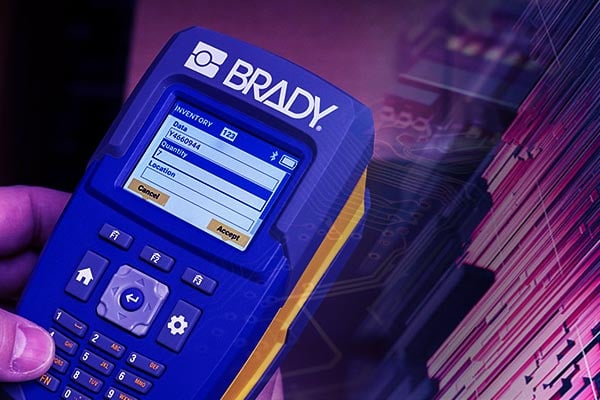 Brady V4500 barcode scanner with a glossy digital grid background.