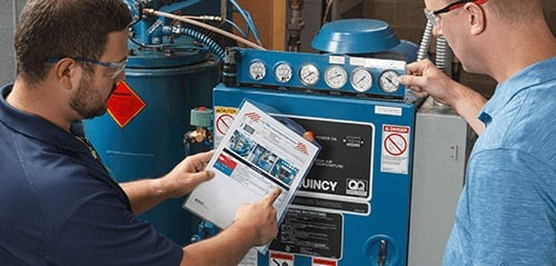 A safety professional reviewing a lockout procedure with a worker in front of the equipment.