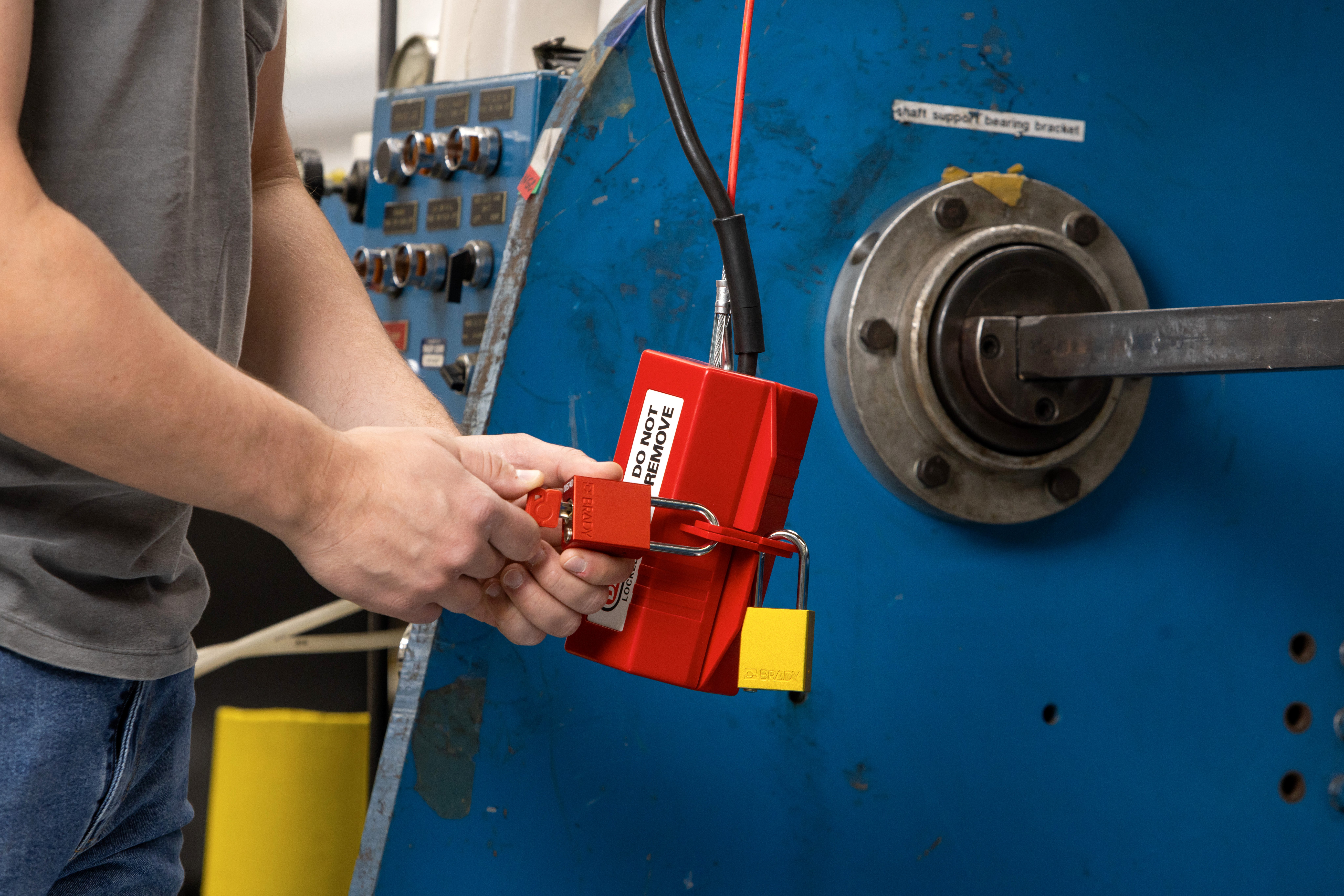 Hand opening one of two padlock to lockout tagout device on a piece of equipment..
