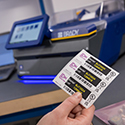A holds up a label to inspect print quality.