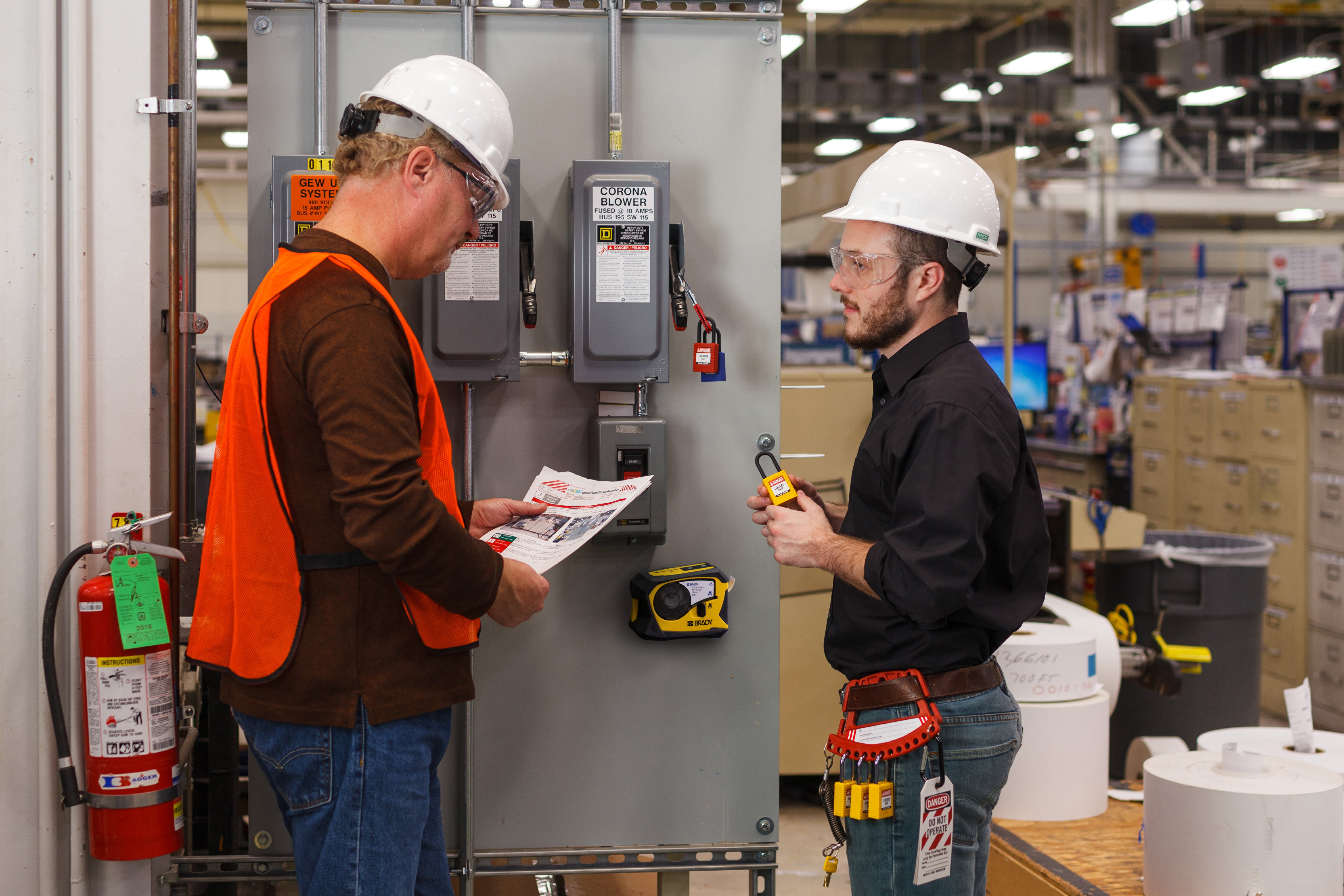 Two workers discuss and set-up Lockout Tagout safety measures